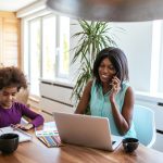 Shot of african american woman working while the daughter is drawing at home. Shot of african american woman working while the daughter is drawing at home.